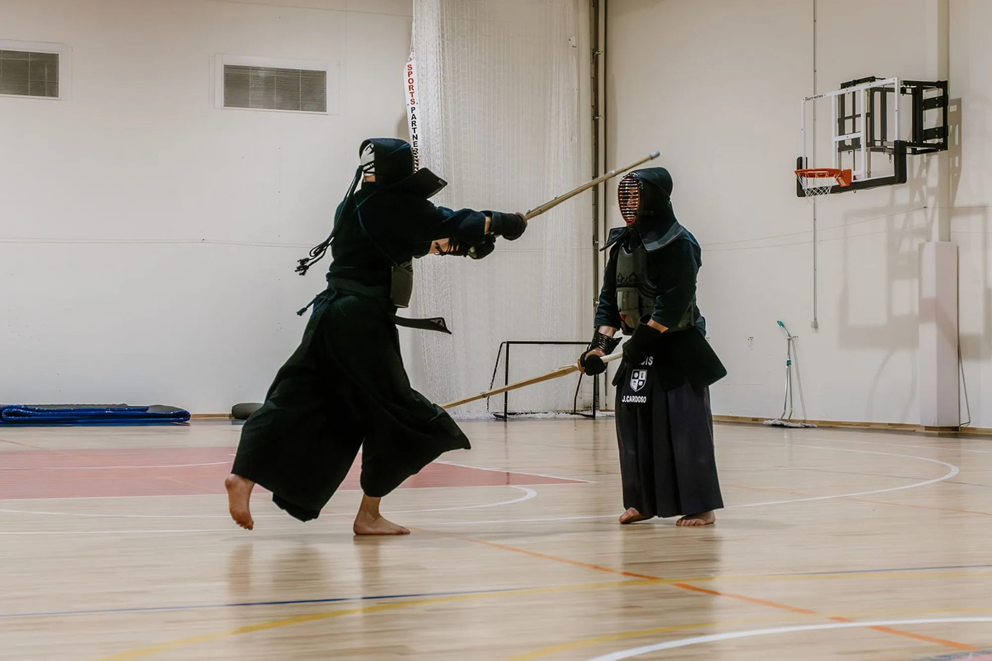 Two kendoka sparring, one lunging forward with raised shinai