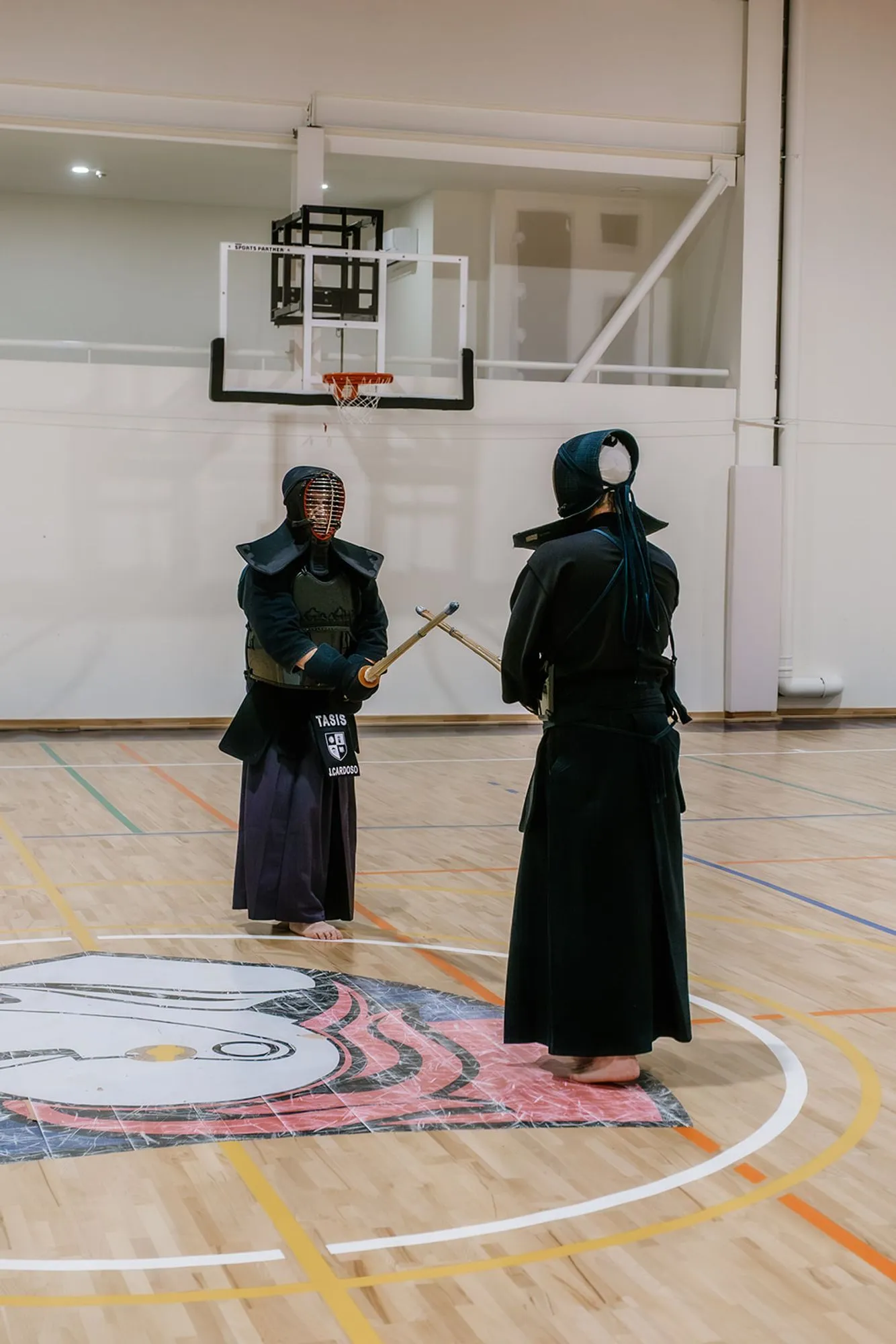 Two kendoka in bogu facing each other, seen from behind