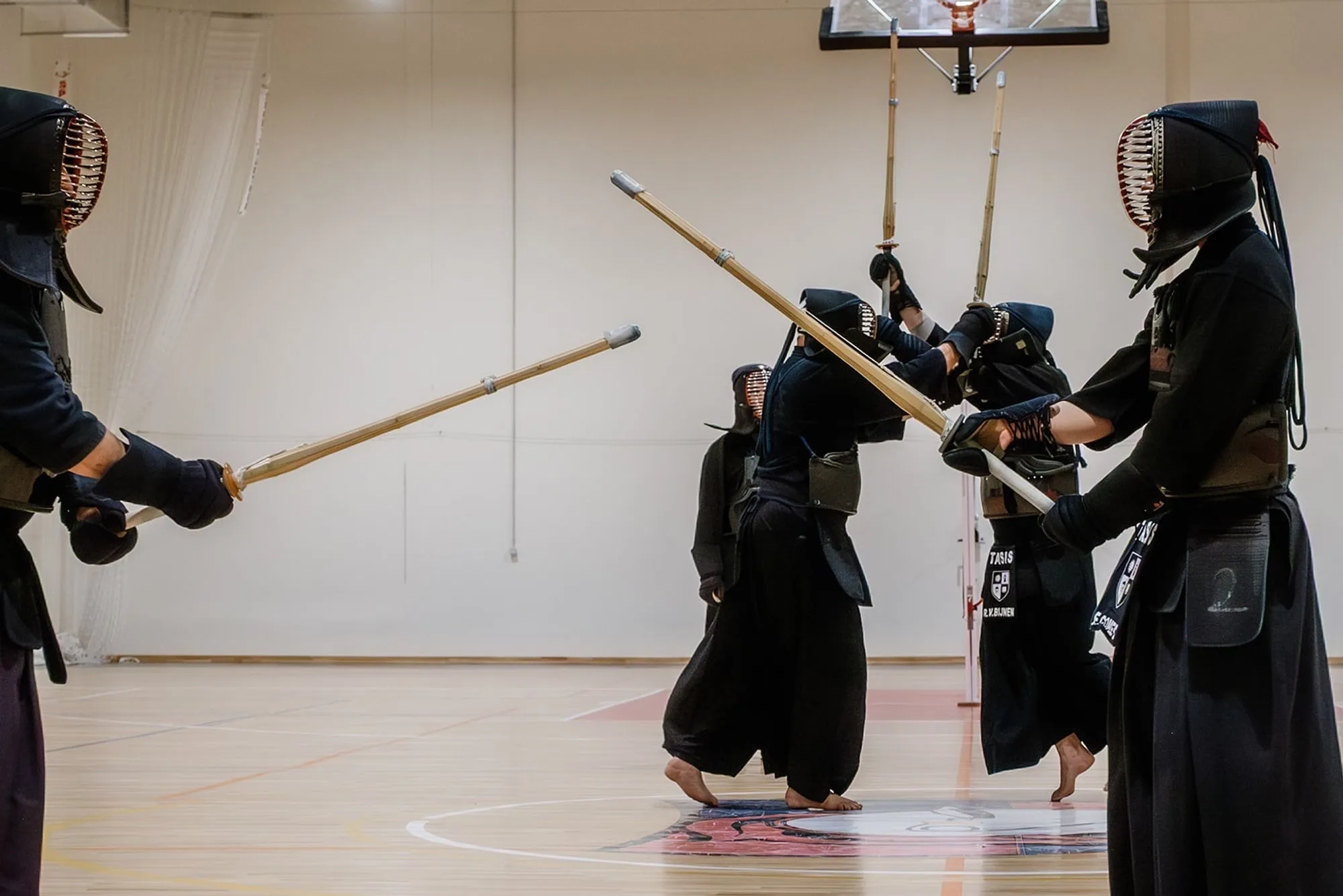 Three kendoka with shinai crossed high above their heads