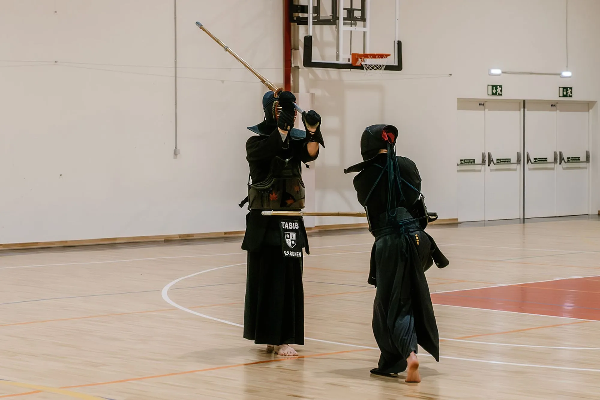 Two kendoka on the court, one lunging into an attack