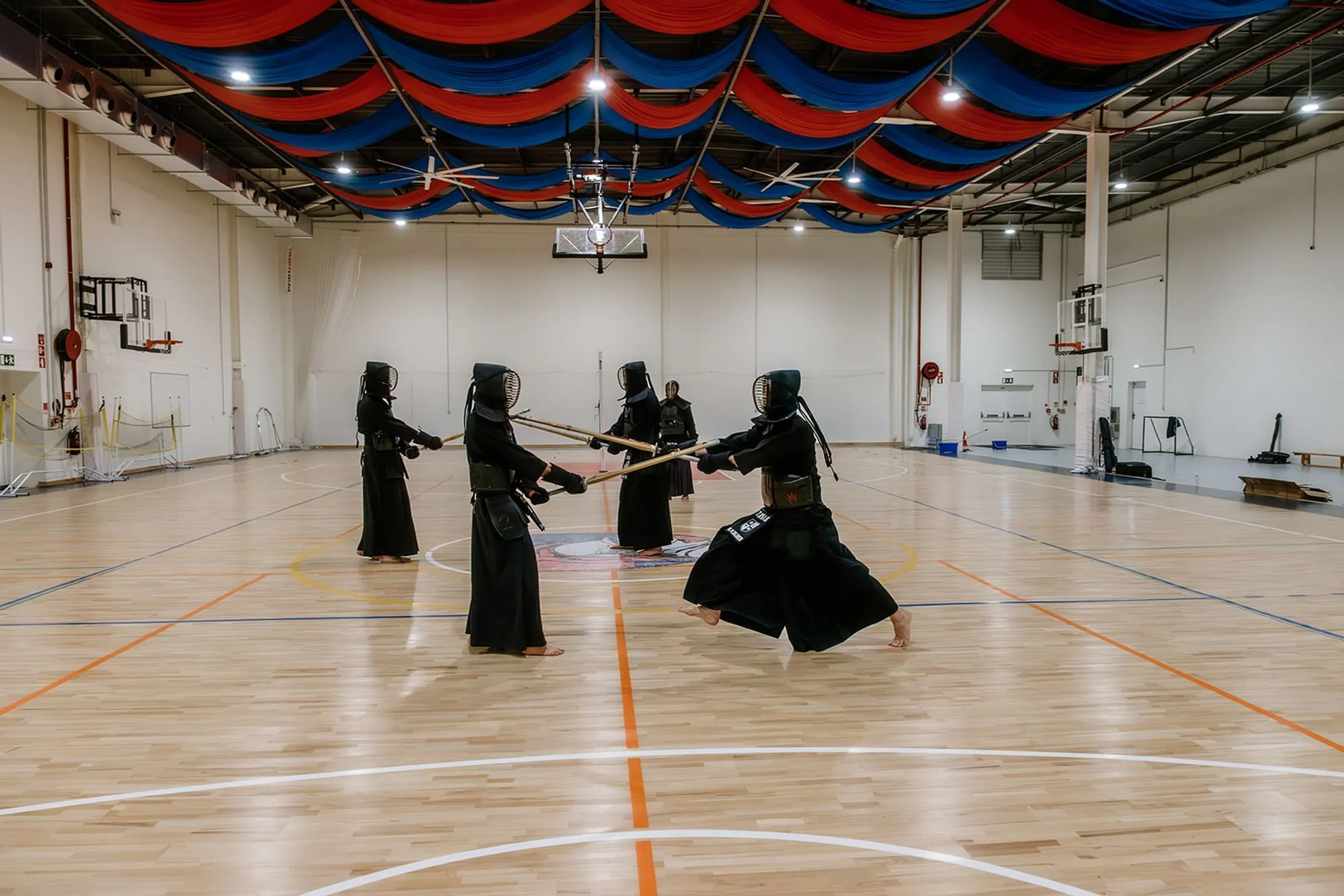 Group training in the hall, red and blue drapes overhead