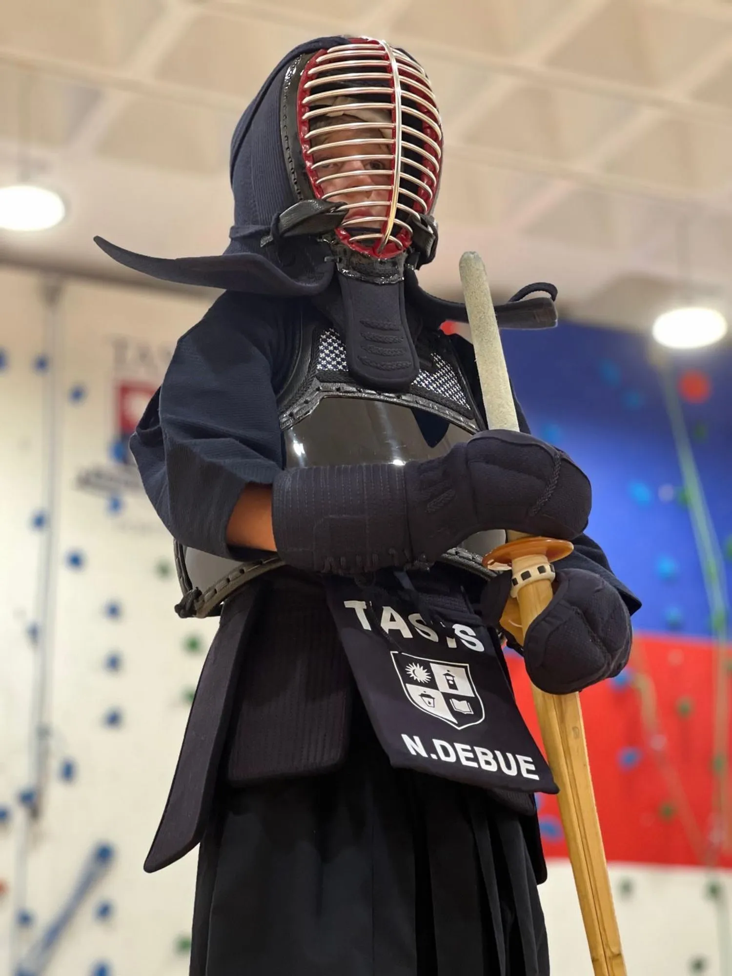 Close view of a kendoka in bogu, club name on the tare